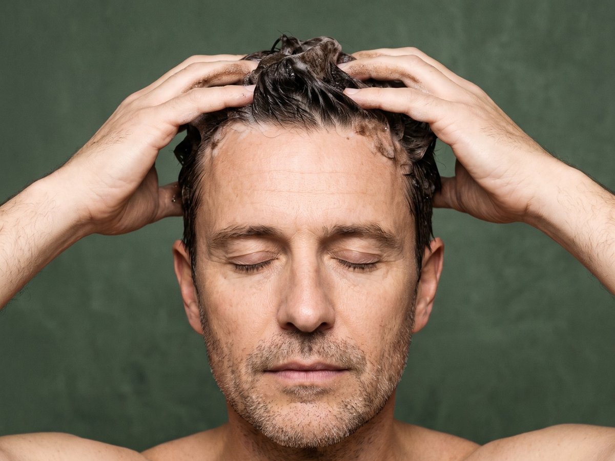 Homme qui applique le shampoing colorant Noria sous la douche